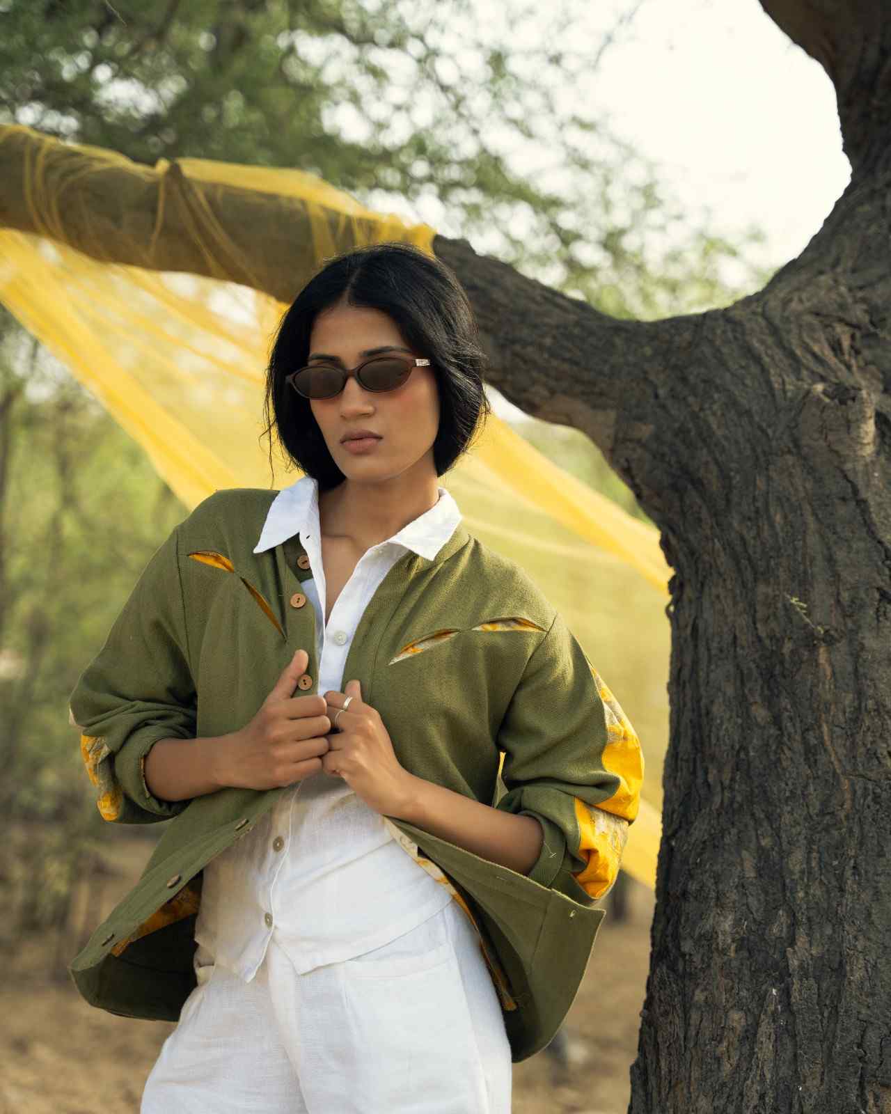 Karanj bomber in olive kala cotton, slash openings showing marigold eco print, sleeves pushed up.